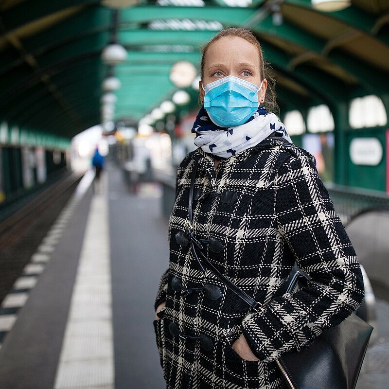 Woman wearing mask waiting for the city train at an almost empty Berlin station