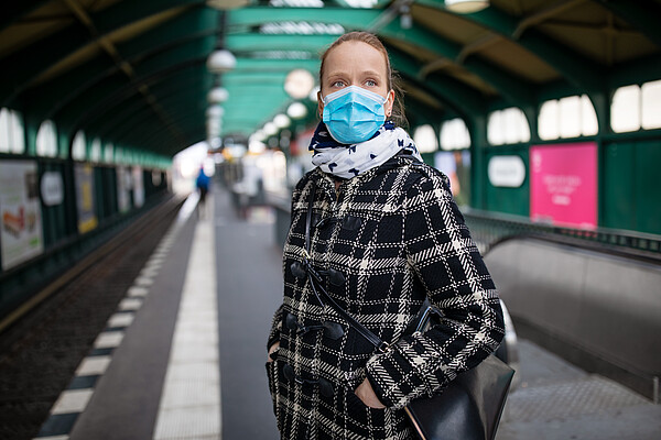 Woman wearing mask waiting for the city train at an almost empty Berlin station