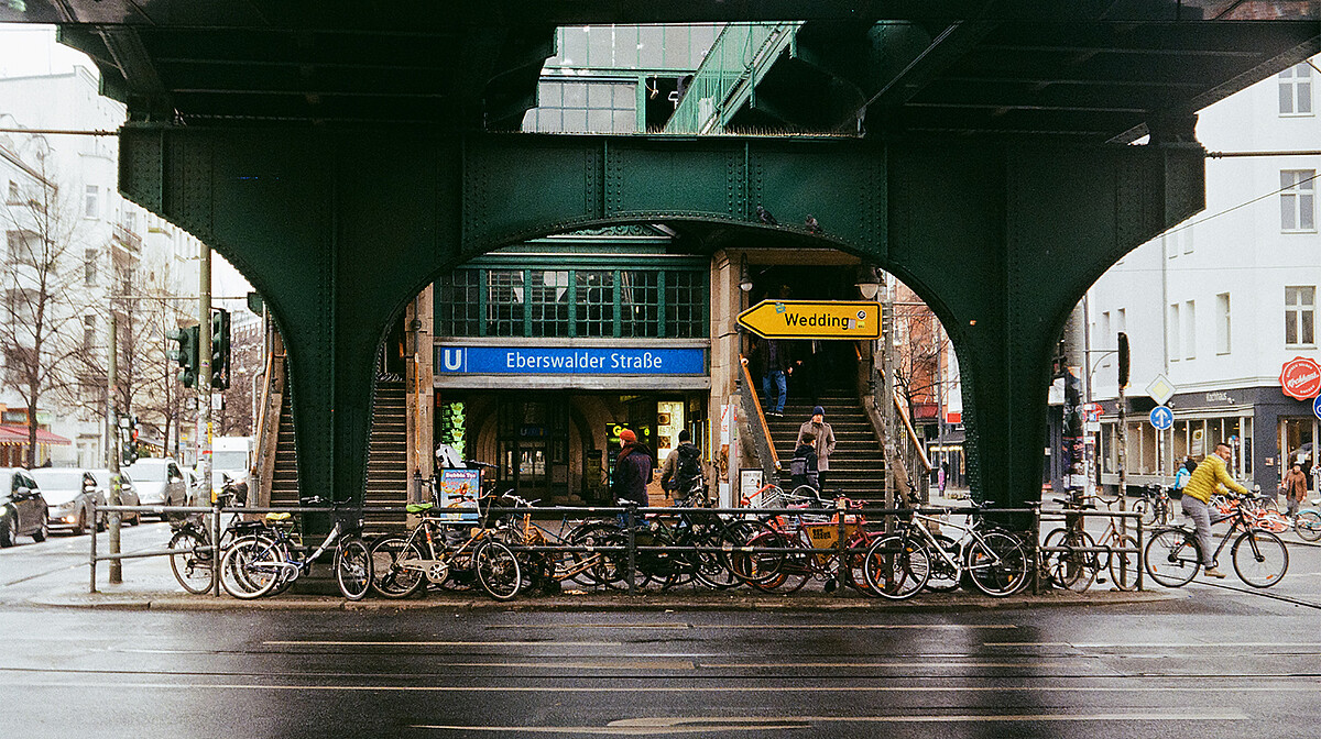 View of Eberswalder Strasse underground station in Berlin, with many bicycles chained to the railings.